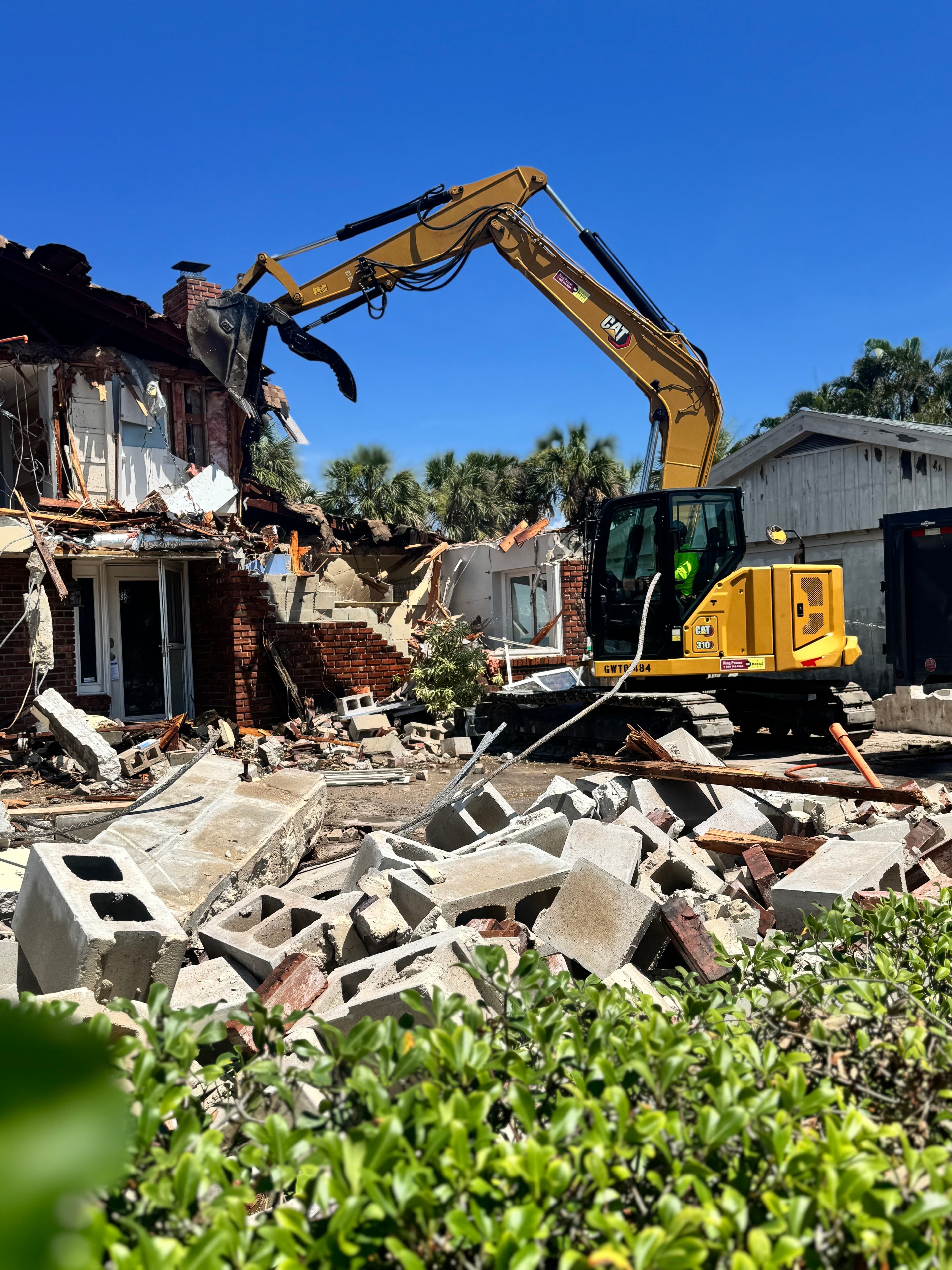 Mojo excavator removing debris from a demolition project