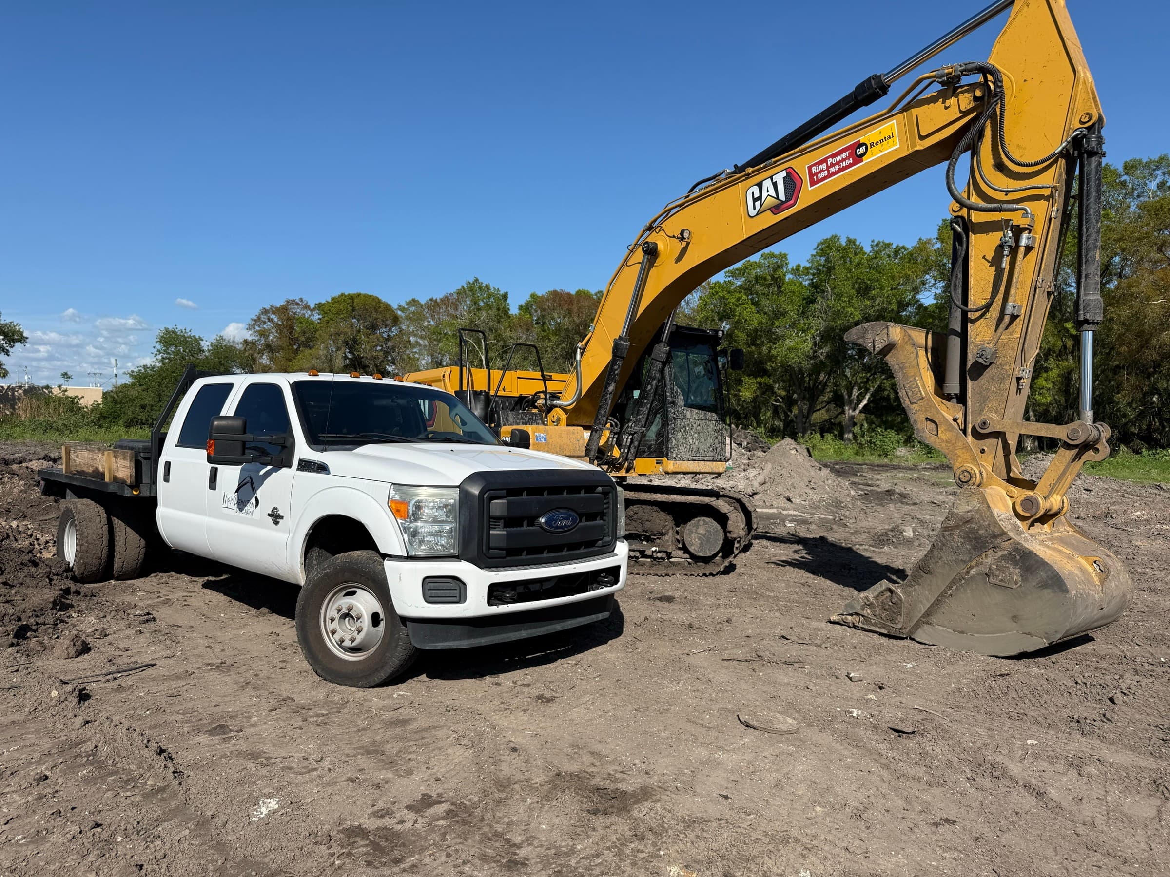 Mojo truck and excavator staged for demolition and excavation work